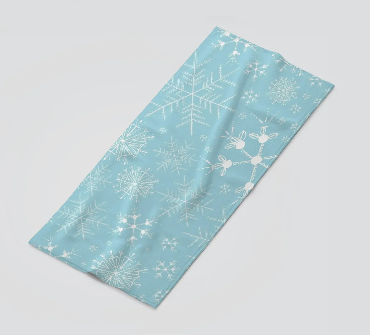 White snowflakes with blue background pattern beach towel by gulsengunel
