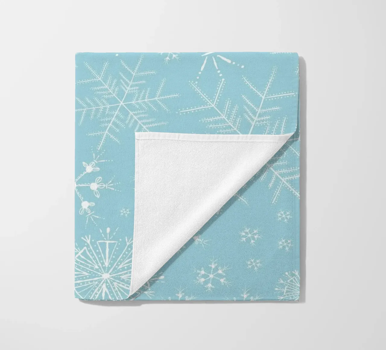White snowflakes with blue background pattern beach towel by gulsengunel