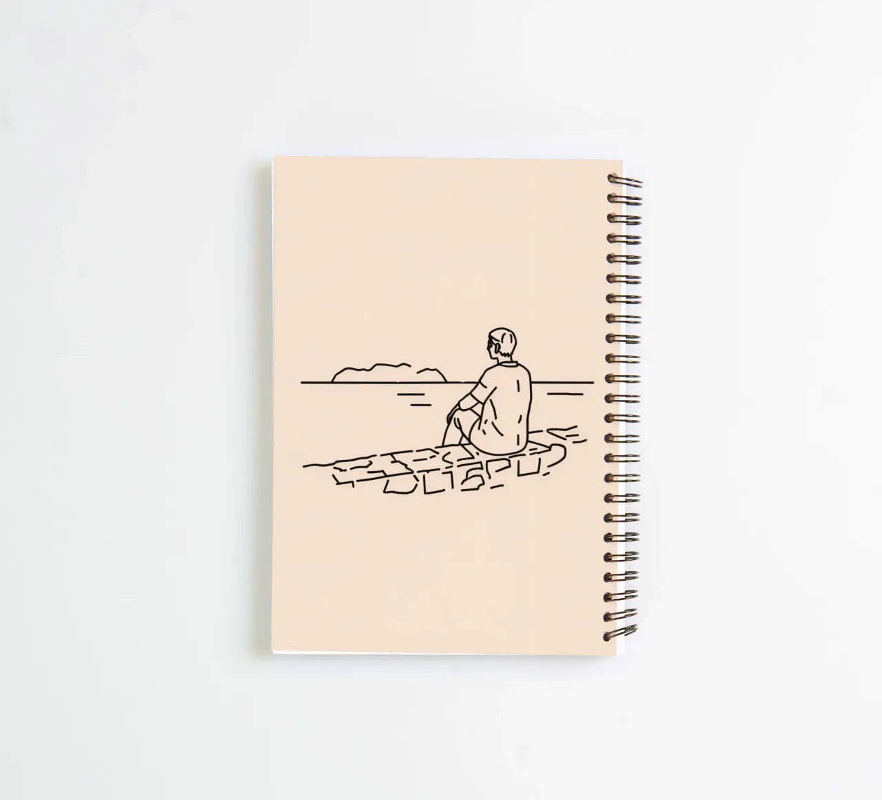 man reflects by the water while sitting on the shore spiral notebook by DesignDoodle