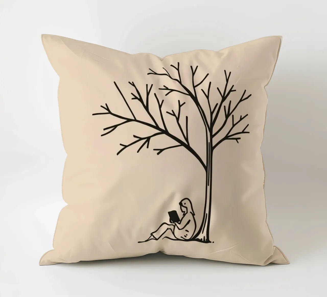 Persona che legge un libro sotto un albero spoglio in un pomeriggio caldo cuscino da DesignDoodle