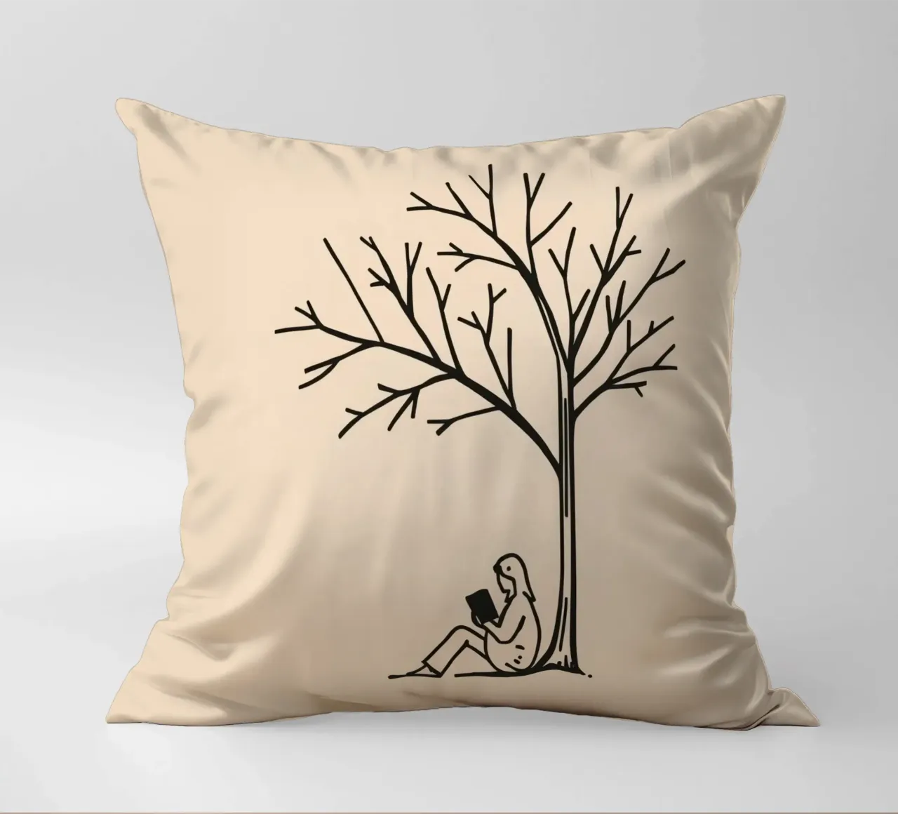 Persona che legge un libro sotto un albero spoglio in un pomeriggio caldo cuscino da DesignDoodle