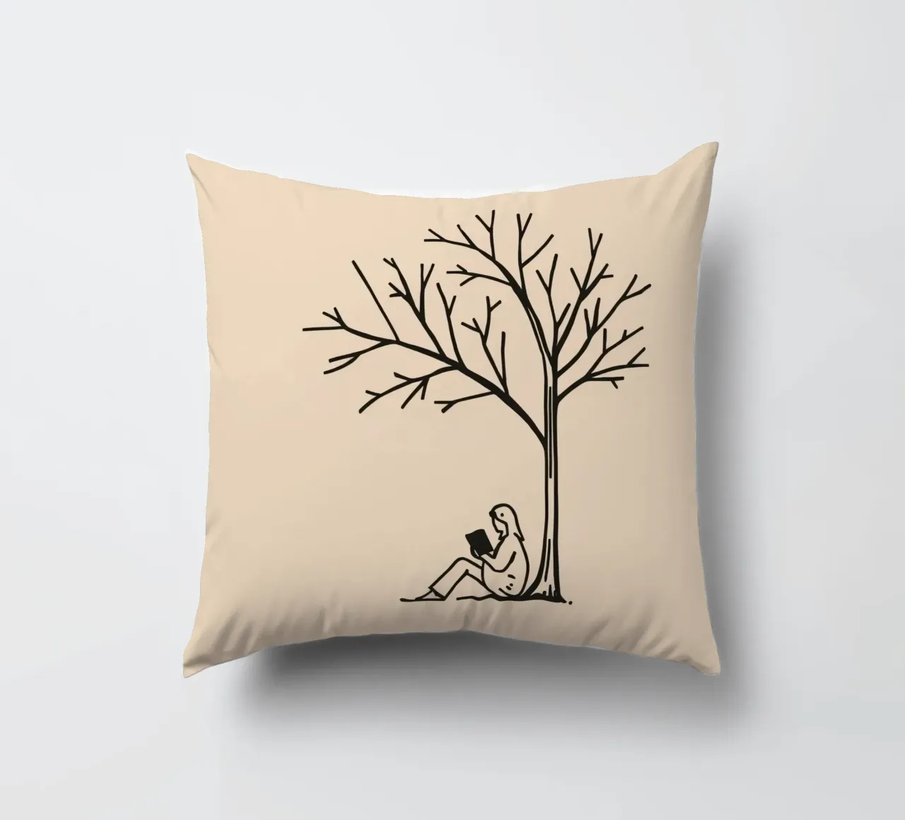Persona che legge un libro sotto un albero spoglio in un pomeriggio caldo cuscino da DesignDoodle