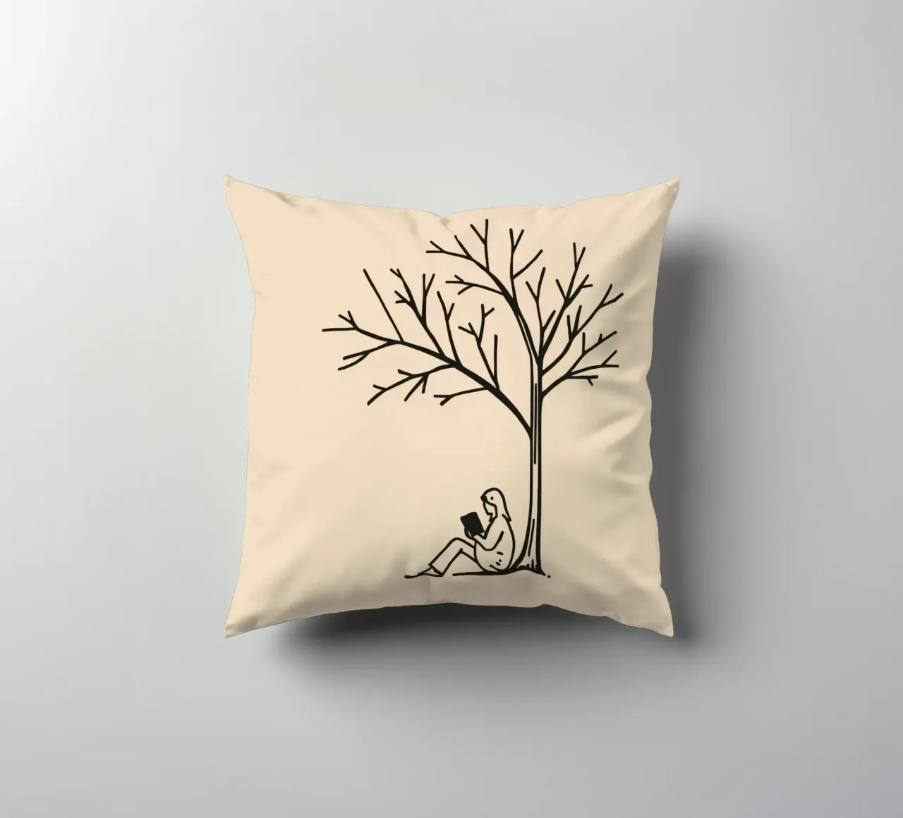 Persona che legge un libro sotto un albero spoglio in un pomeriggio caldo cuscino da DesignDoodle