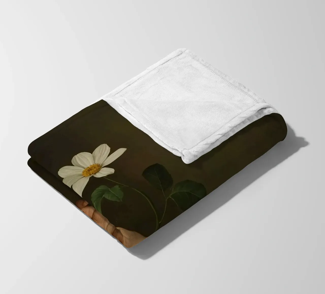 Mano che regge un fiore bianco in una luce soffusa con coperta in pile da DesignDoodle