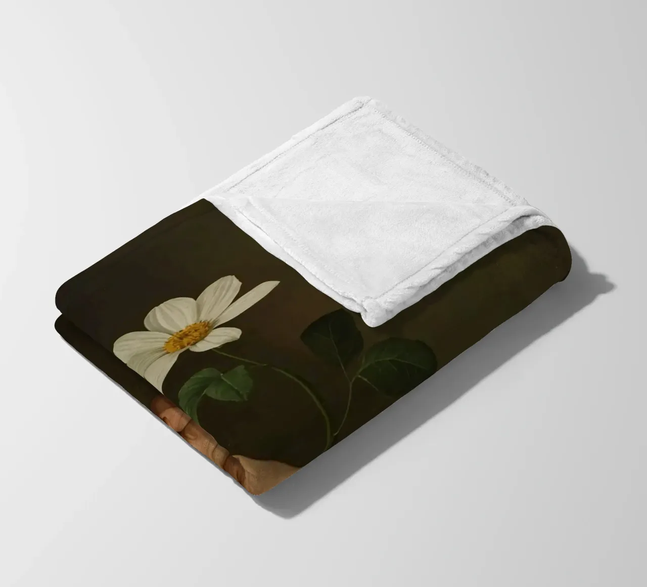Mano che regge un fiore bianco in una luce soffusa con coperta in pile da DesignDoodle