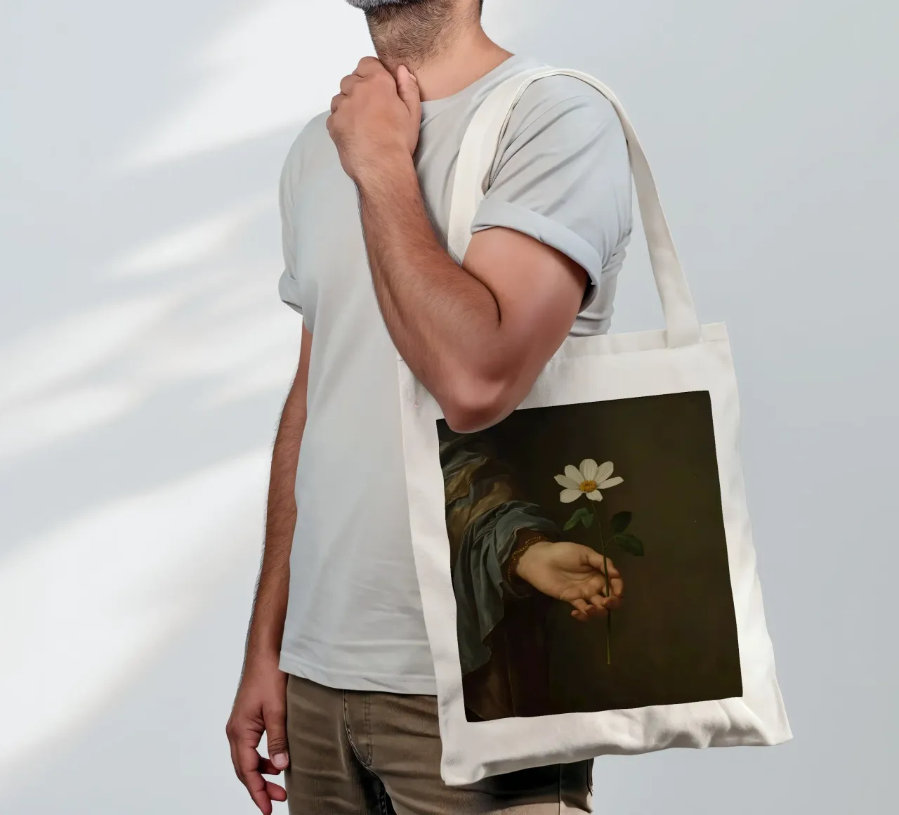 Mano che regge un fiore bianco in una luce soffusa con borsa in juta da DesignDoodle