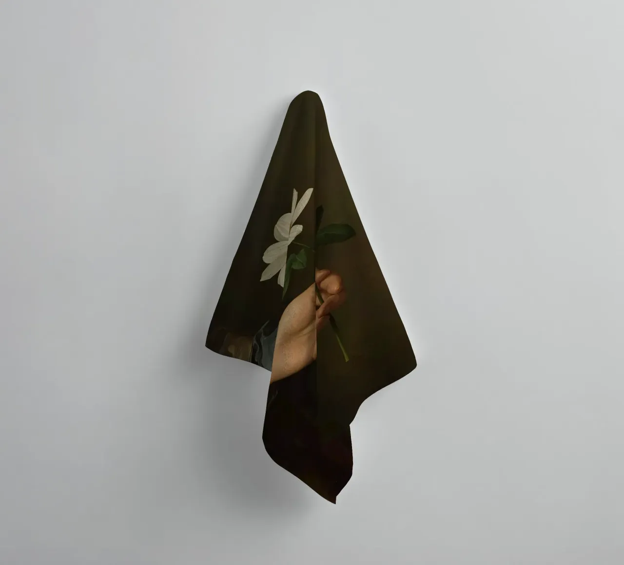 Main tenant une fleur blanche dans une lumière douce et atténuée. serviette de bain de DesignDoodle