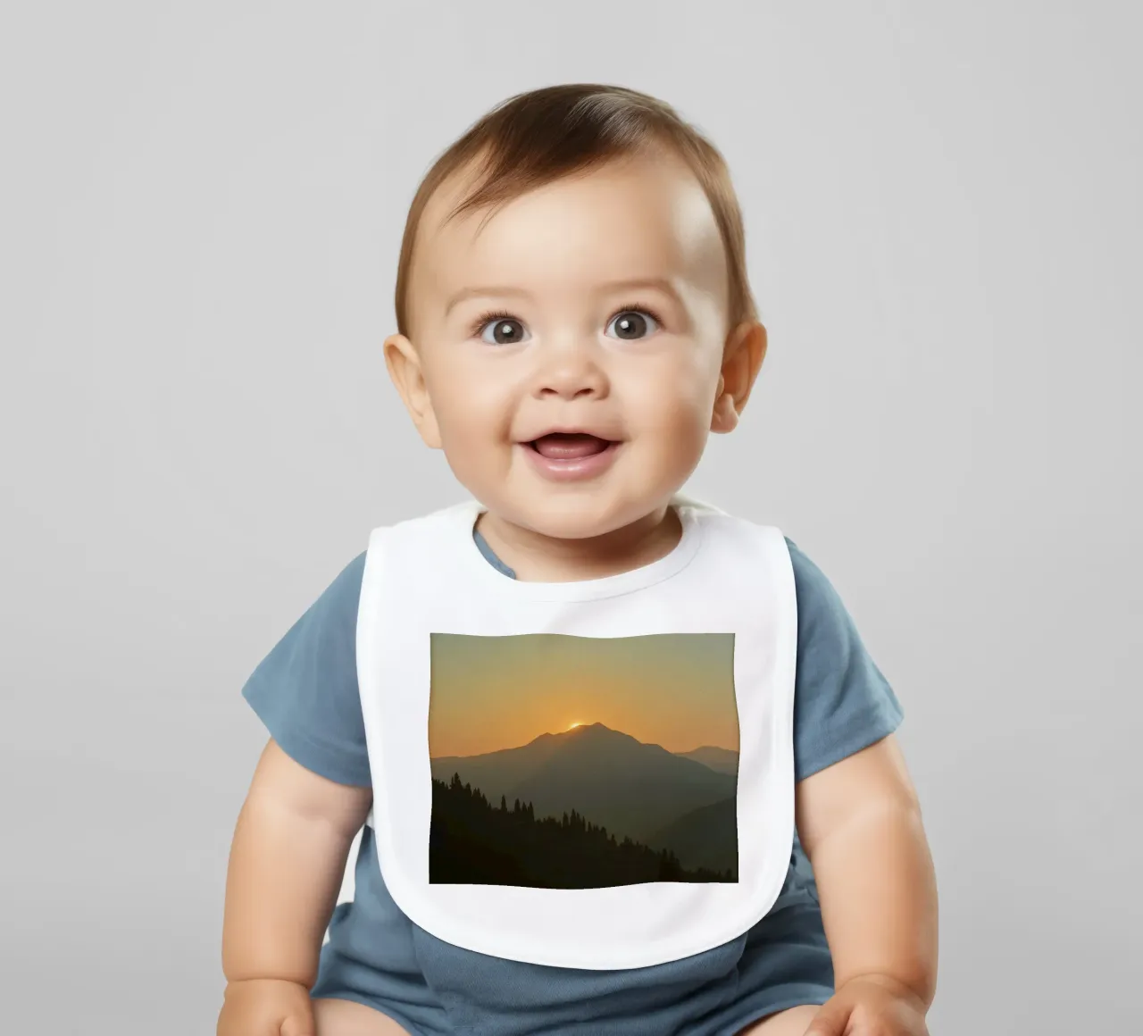 Zonsondergang werpt schaduwen over bergen en pijnbomen baby slabbetje van DesignDoodle