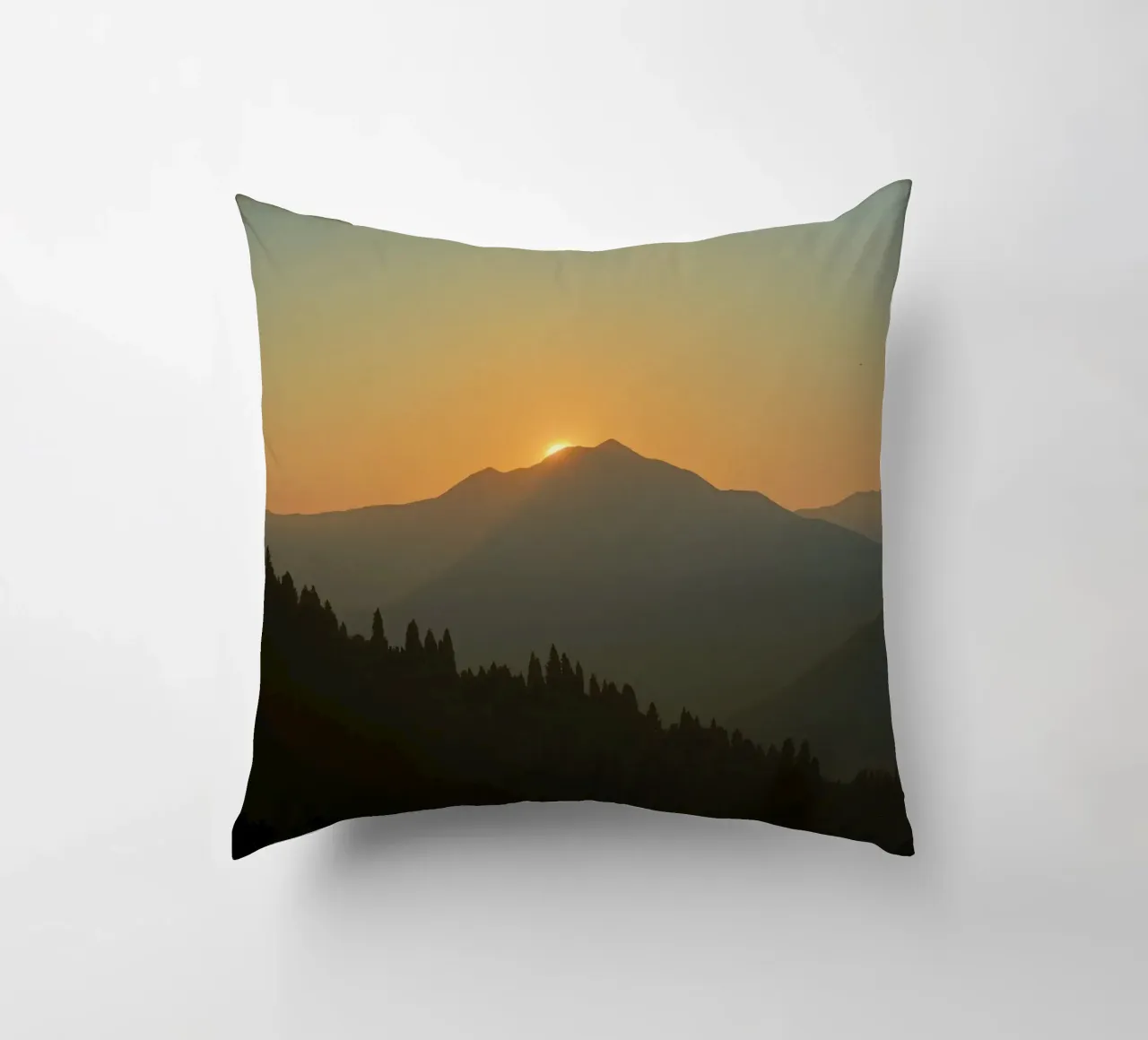 Zonsondergang werpt schaduwen over bergen en pijnbomen kussen van DesignDoodle