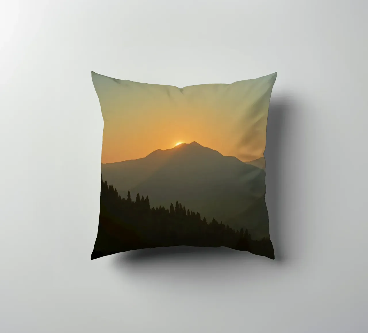 Zonsondergang werpt schaduwen over bergen en pijnbomen kussen van DesignDoodle