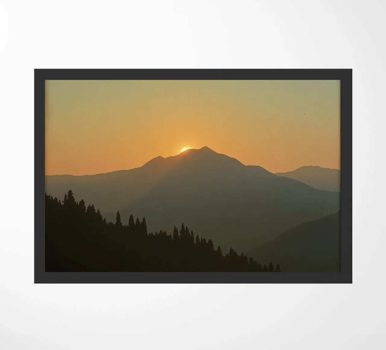 Sunset casting shadows over mountains and pine trees doormat by DesignDoodle