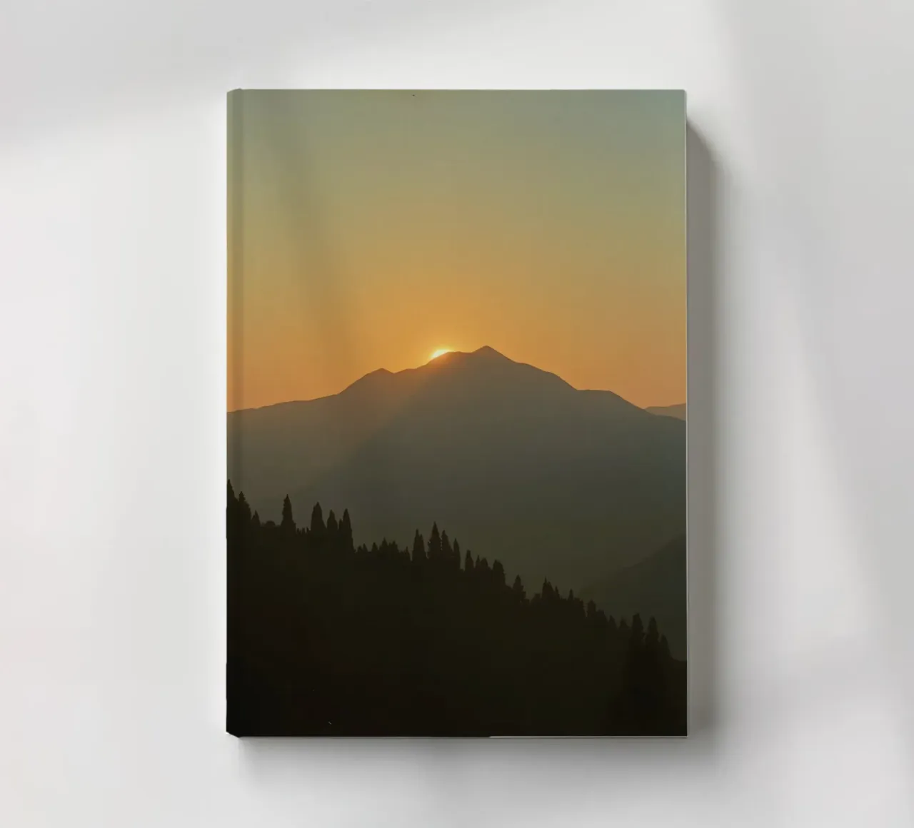 Zonsondergang werpt schaduwen over bergen en pijnbomen notitieboek van DesignDoodle