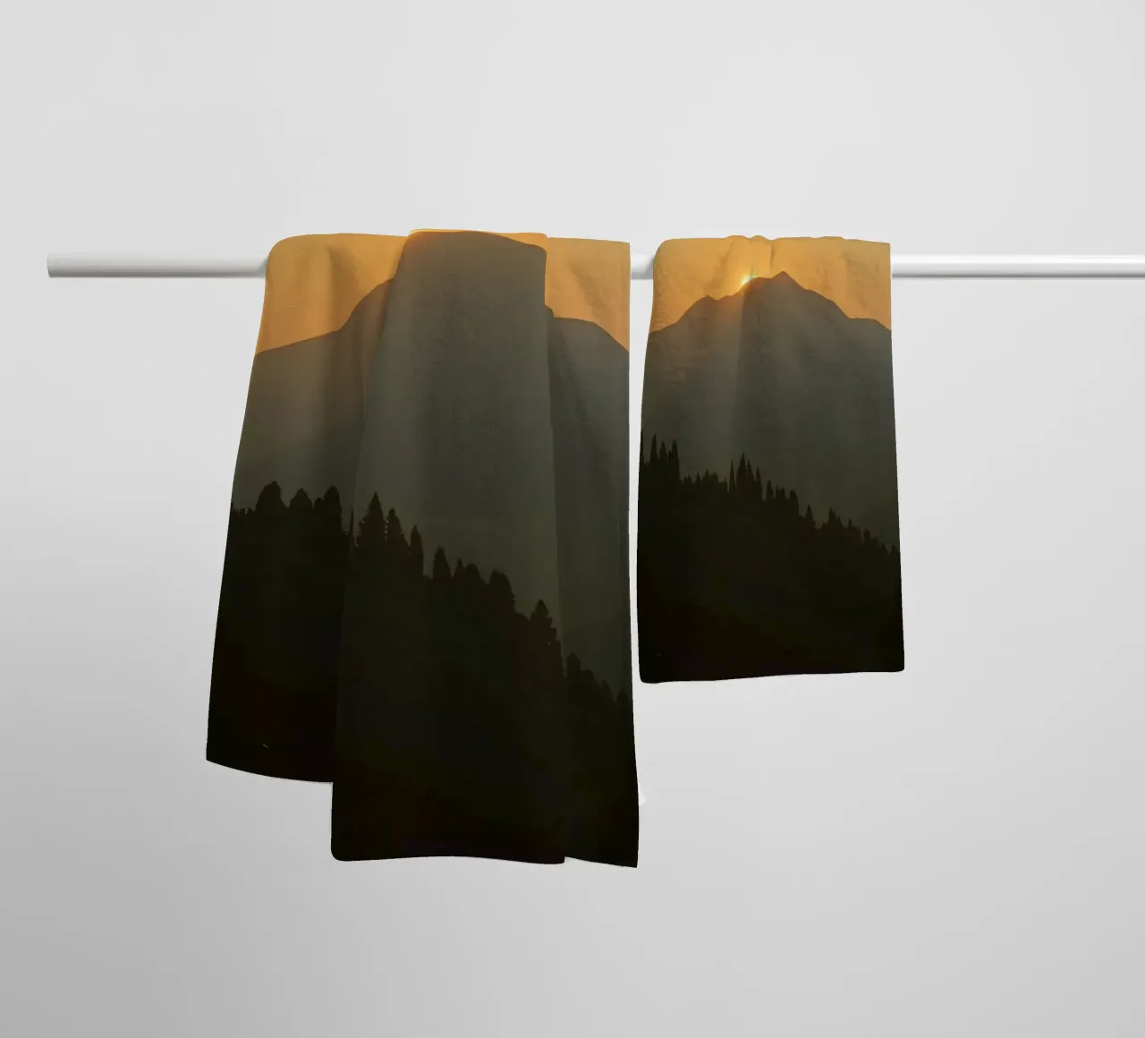 Zonsondergang werpt schaduwen over bergen en pijnbomen badhanddoek van DesignDoodle