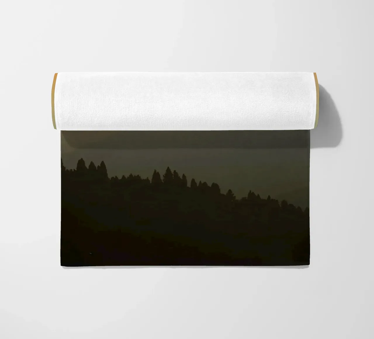 Zonsondergang werpt schaduwen over bergen en pijnbomen strandhanddoek van DesignDoodle