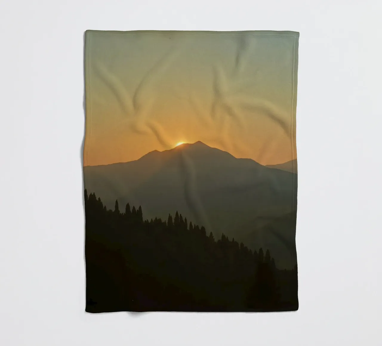 Sunset casting shadows over mountains and pine trees fleece blanket by DesignDoodle