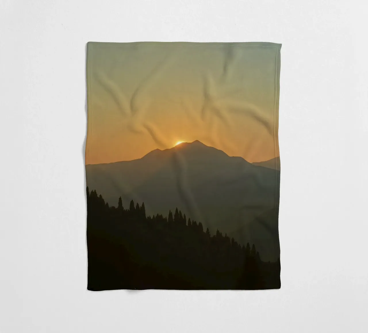 Sunset casting shadows over mountains and pine trees fleece blanket by DesignDoodle