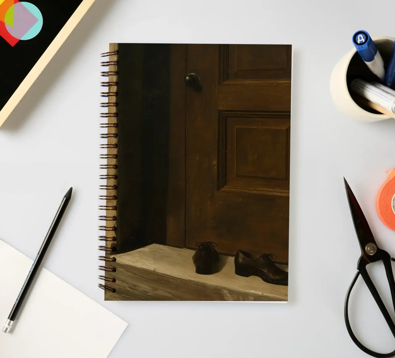 Doorway with black shoes resting on a concrete step under so spiral notebook by DesignDoodle