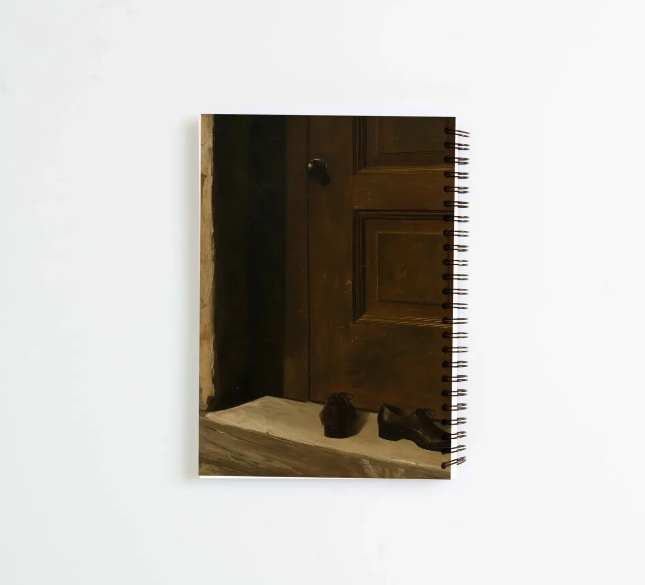 Doorway with black shoes resting on a concrete step under so spiral notebook by DesignDoodle