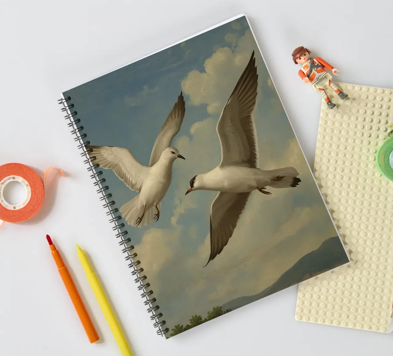 Two seagulls in mid-flight against a backdrop of clouds spiral notebook by DesignDoodle