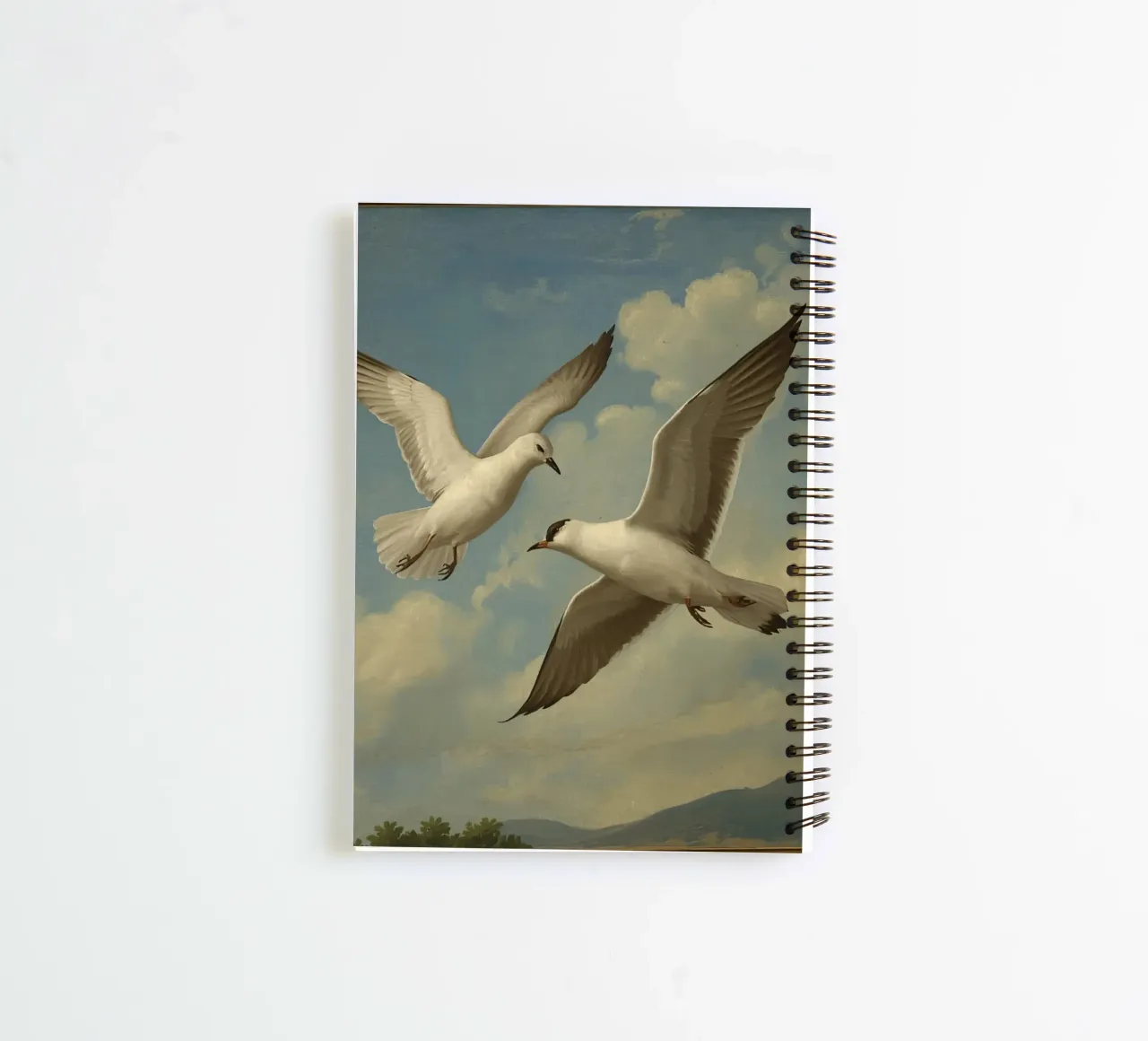 Two seagulls in mid-flight against a backdrop of clouds spiral notebook by DesignDoodle