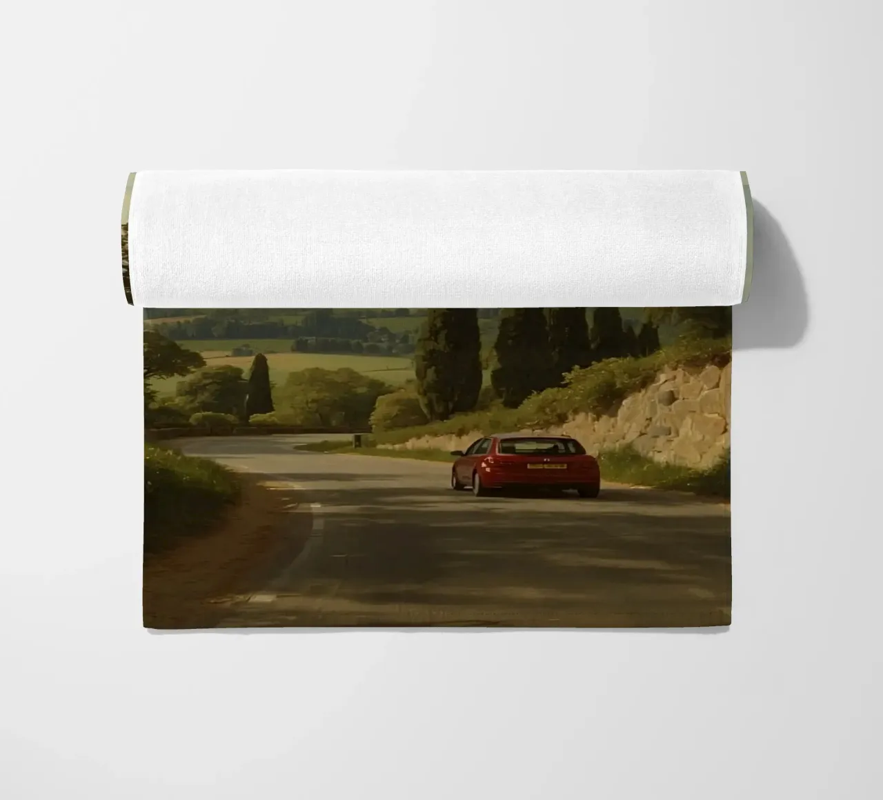 Superbe vue de la campagne avec une voiture roulant le long d'une route sinueuse. serviette de plage de DesignDoodle