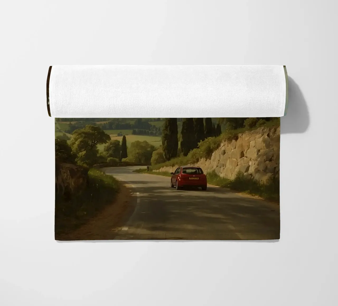Superbe vue de la campagne avec une voiture roulant le long d'une route sinueuse. serviette de plage de DesignDoodle