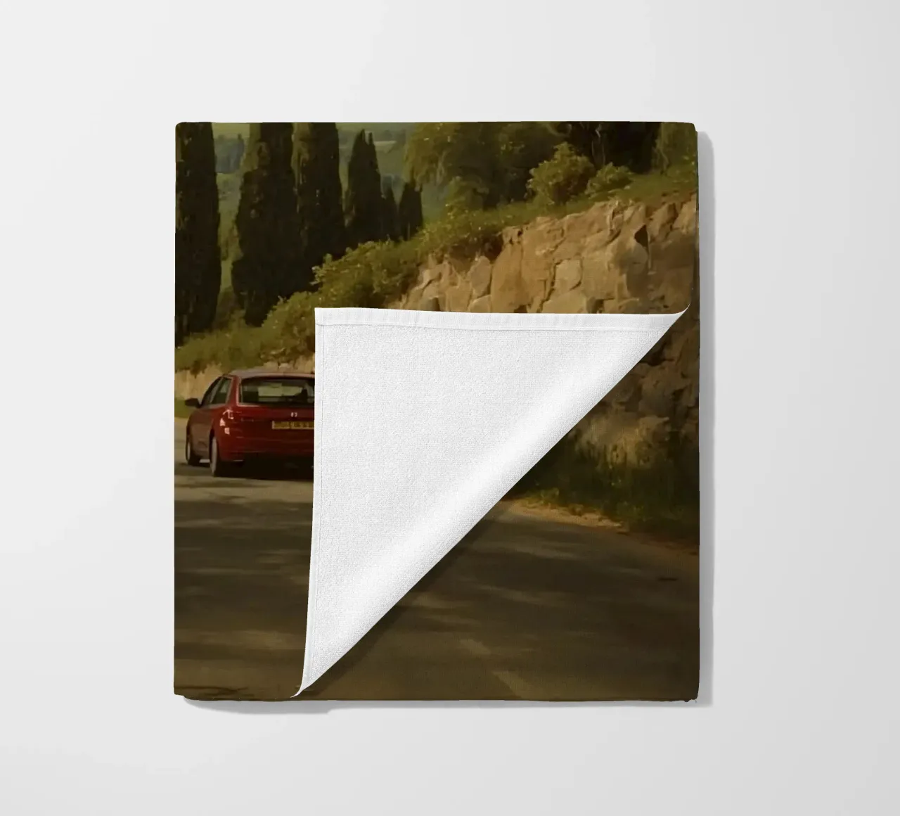 Superbe vue de la campagne avec une voiture roulant le long d'une route sinueuse. serviette de plage de DesignDoodle