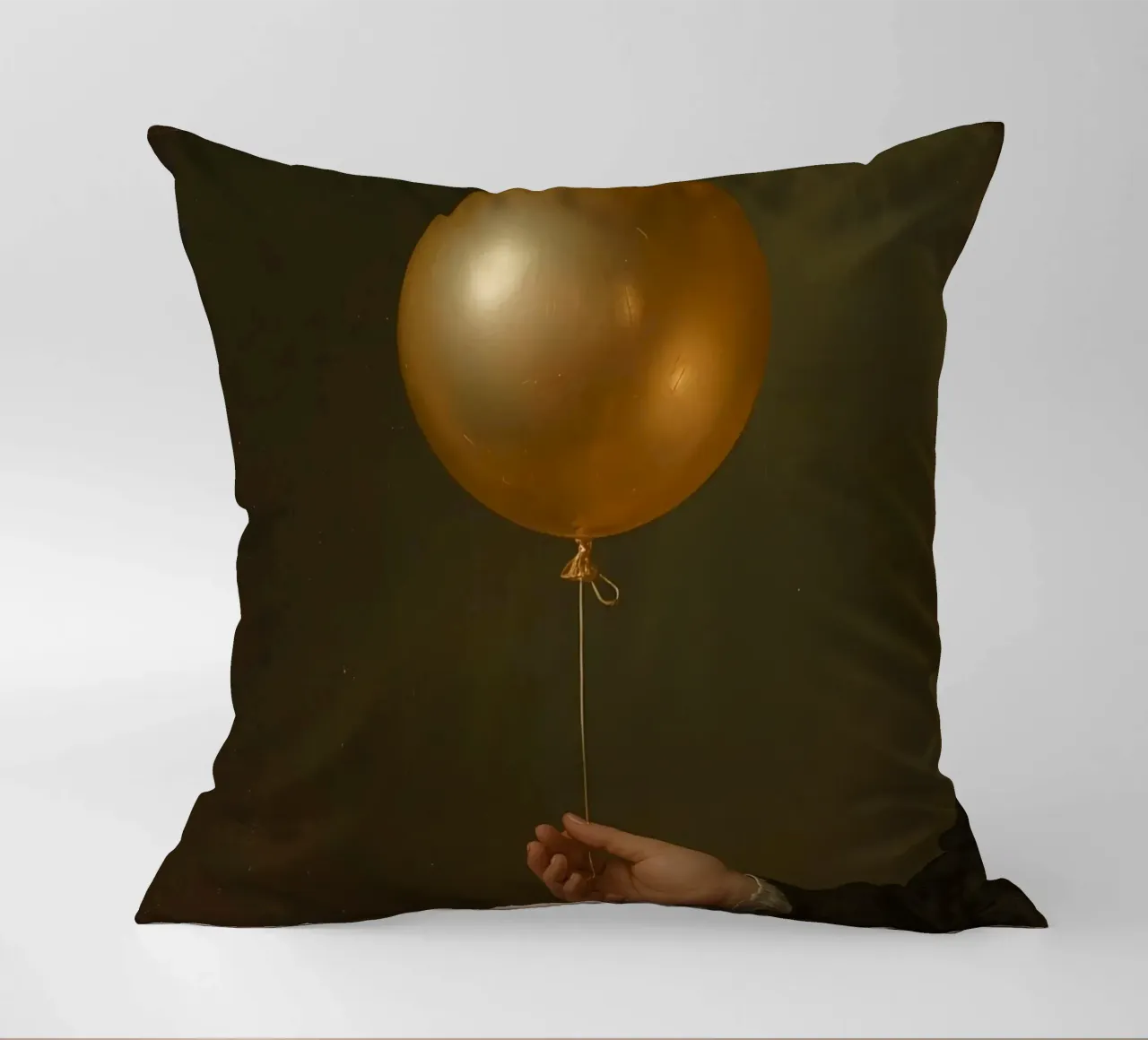 Pallone d'oro tenuto da una mano su uno sfondo scuro cuscino da DesignDoodle