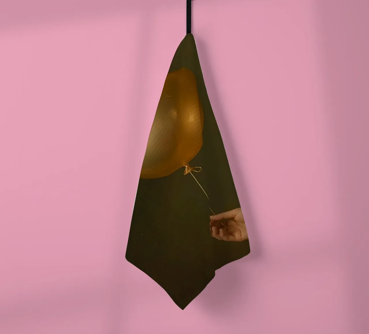 Goldener Luftballon, der von einer Hand vor einem dunklen Hintergrund gehalten wird Geschirrtuch von DesignDoodle