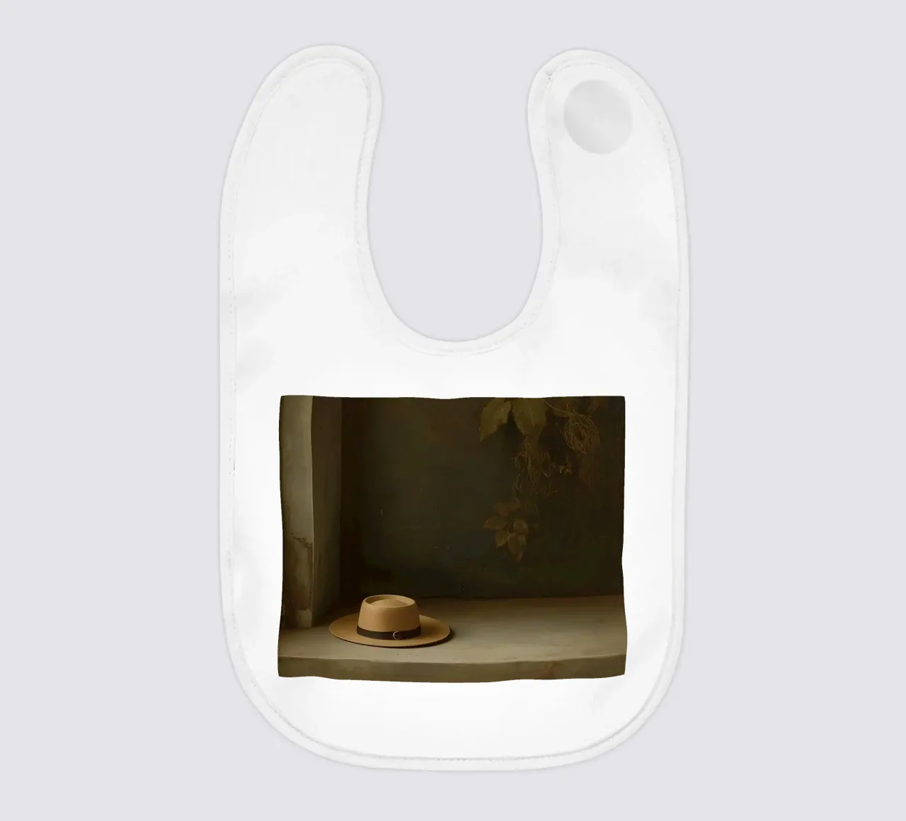 Cappello appoggiato su una superficie con foglie in un ambiente muto bavaglino da DesignDoodle