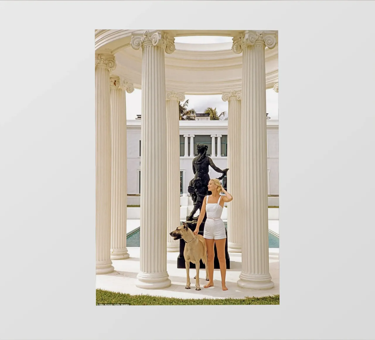 Slim Aarons - Frau trägt Hund Fototapete von The Poster UK