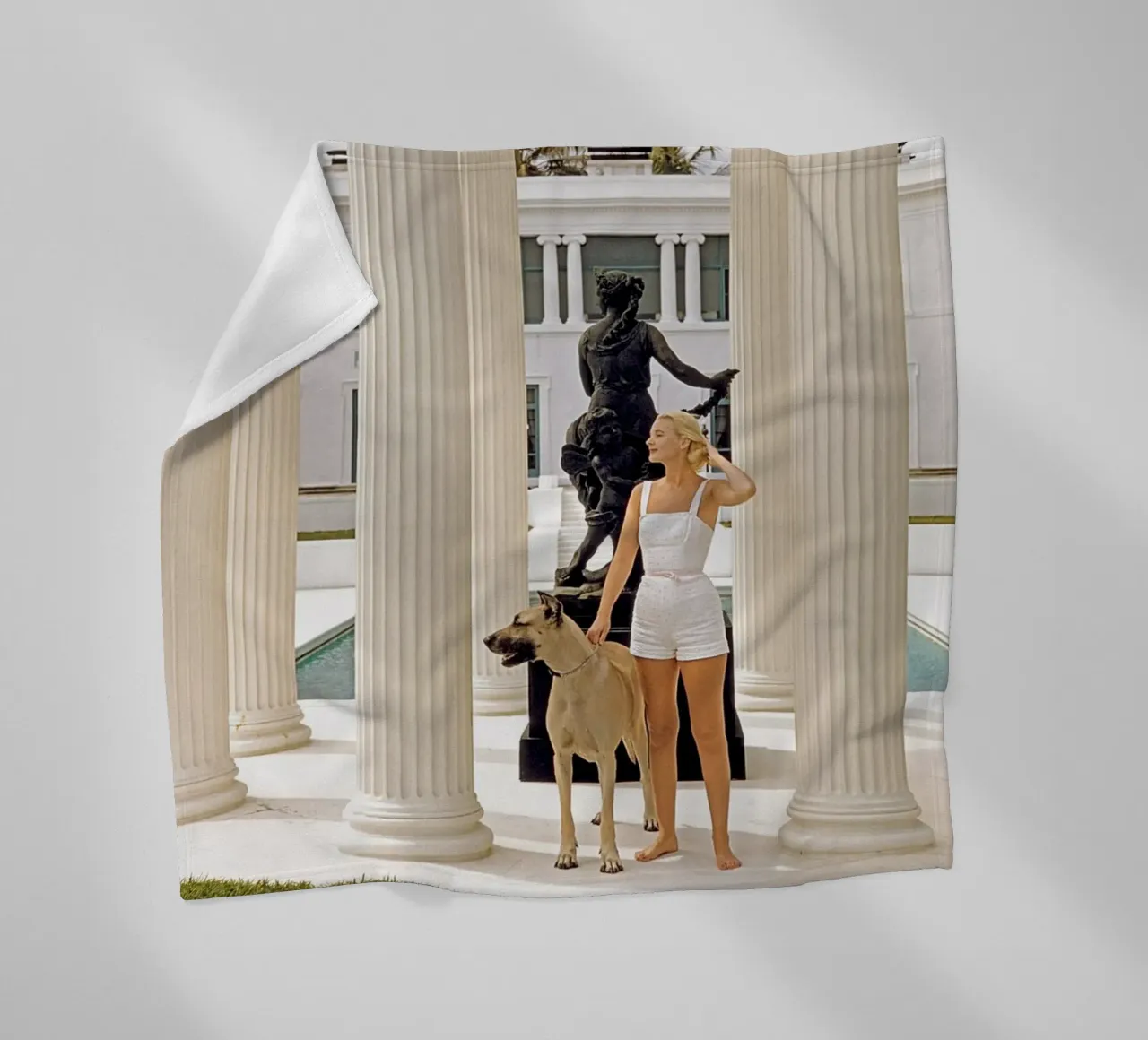 Slim Aarons - Donna che porta il cane coperta in pile da The Poster UK