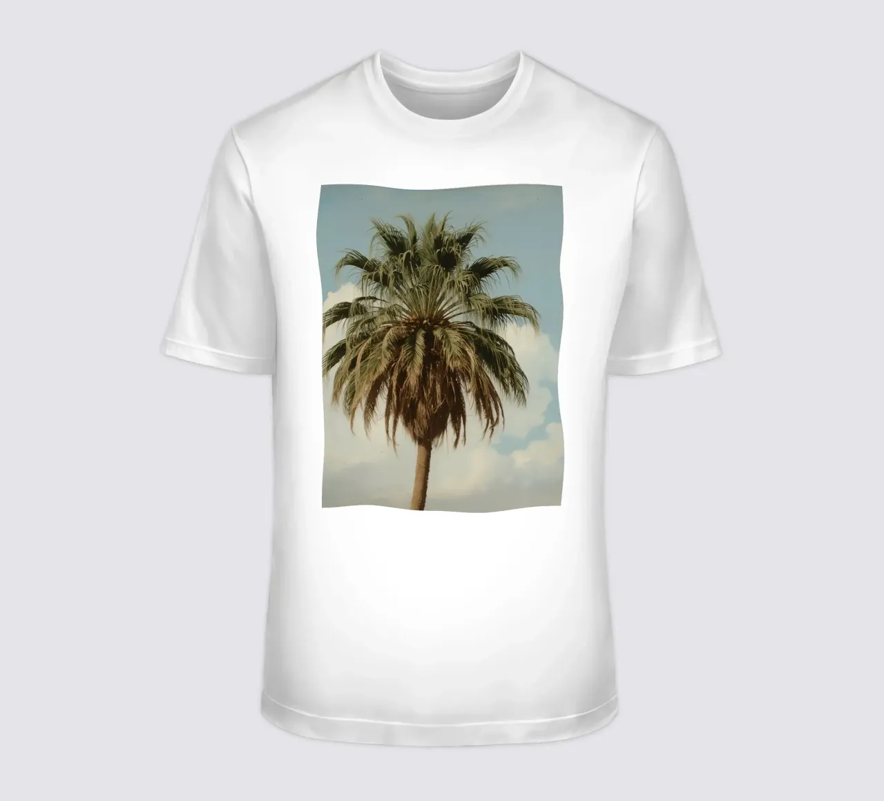 Tall palm tree with blue sky with fluffy clouds in warm ligh t-shirt by DesignDoodle