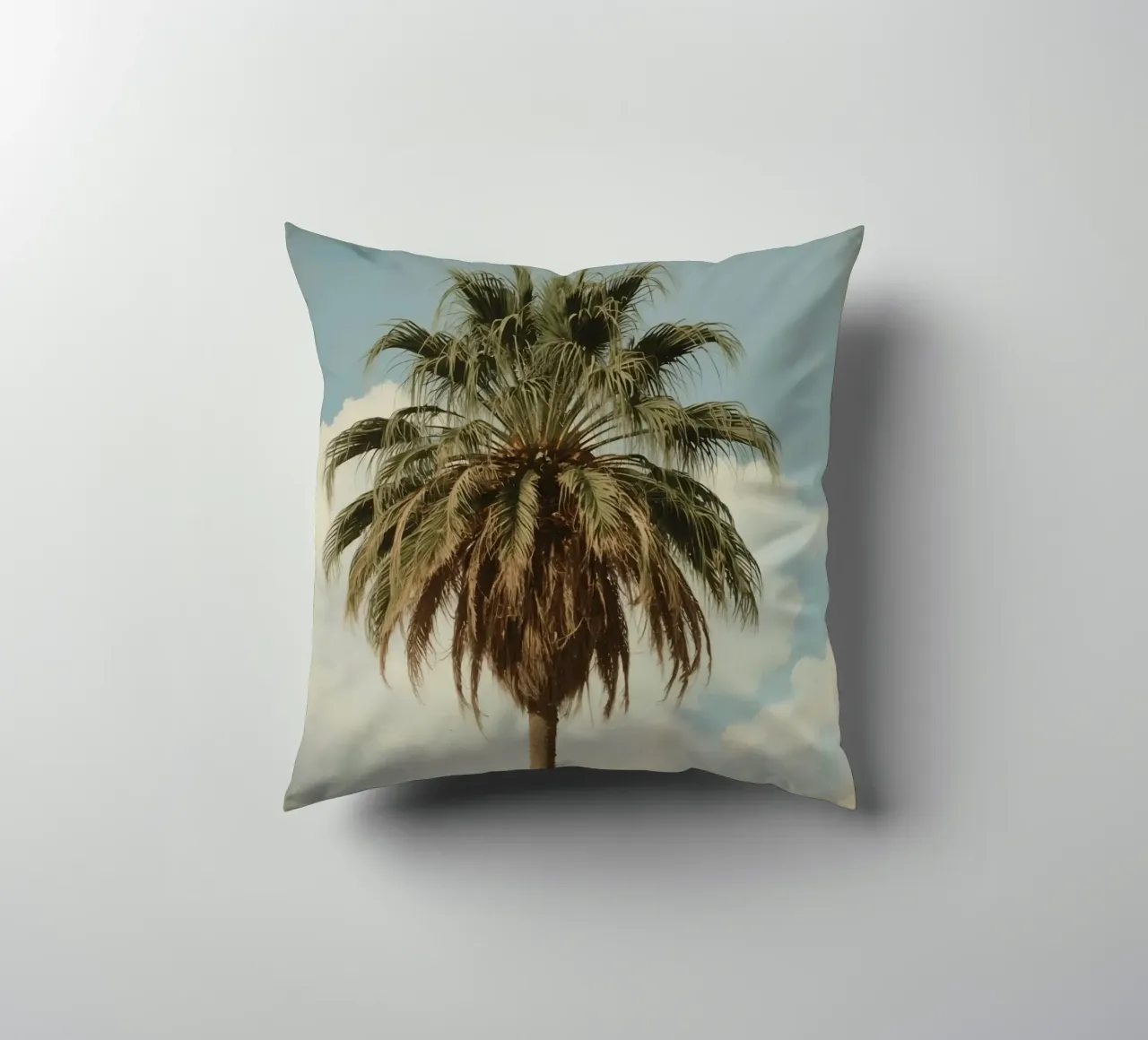 Palma alta con cielo blu e nuvole soffici in una luce calda. cuscino da DesignDoodle