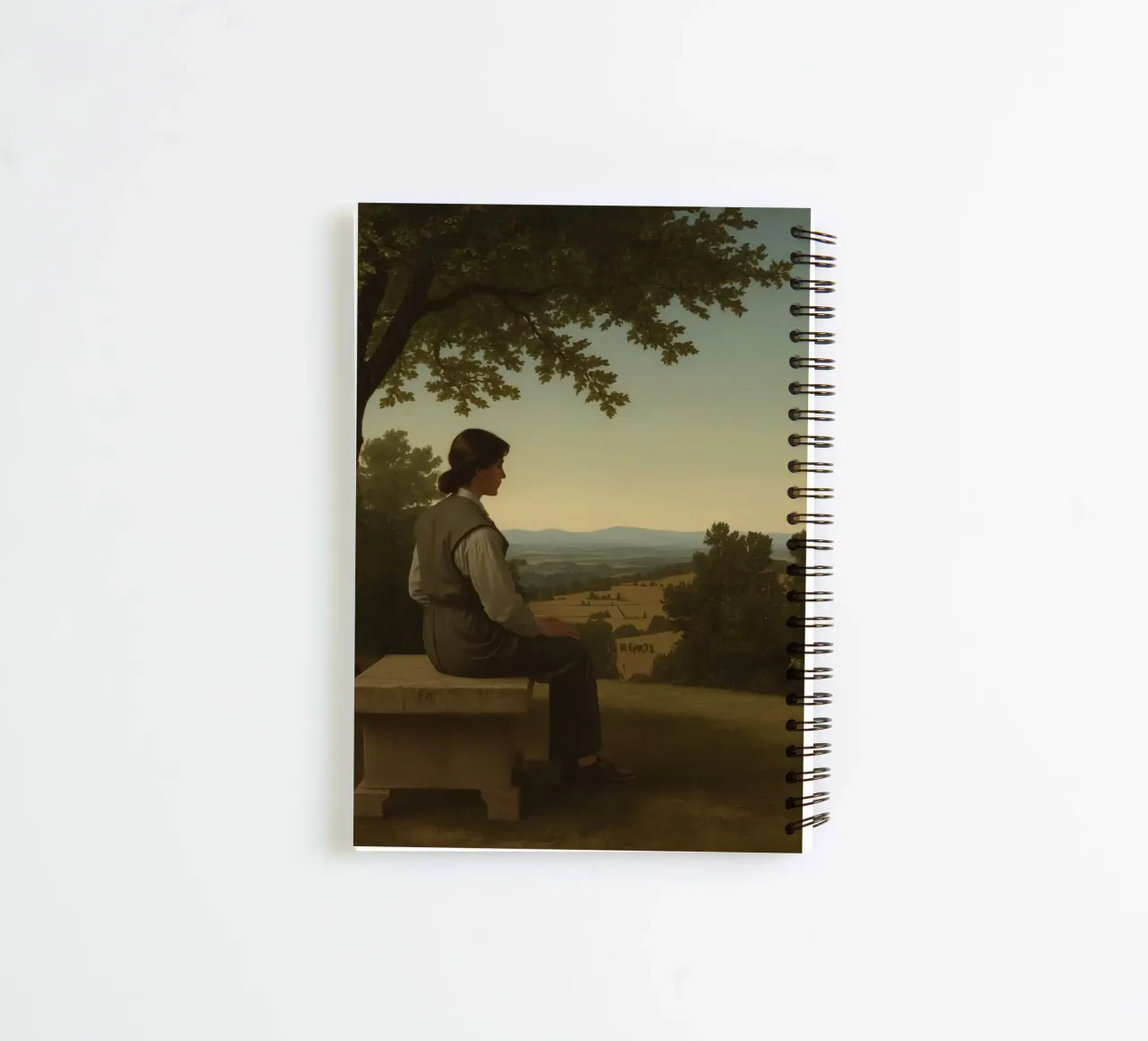 man seated on a stone bench reflecting on a landscape spiral notebook by DesignDoodle