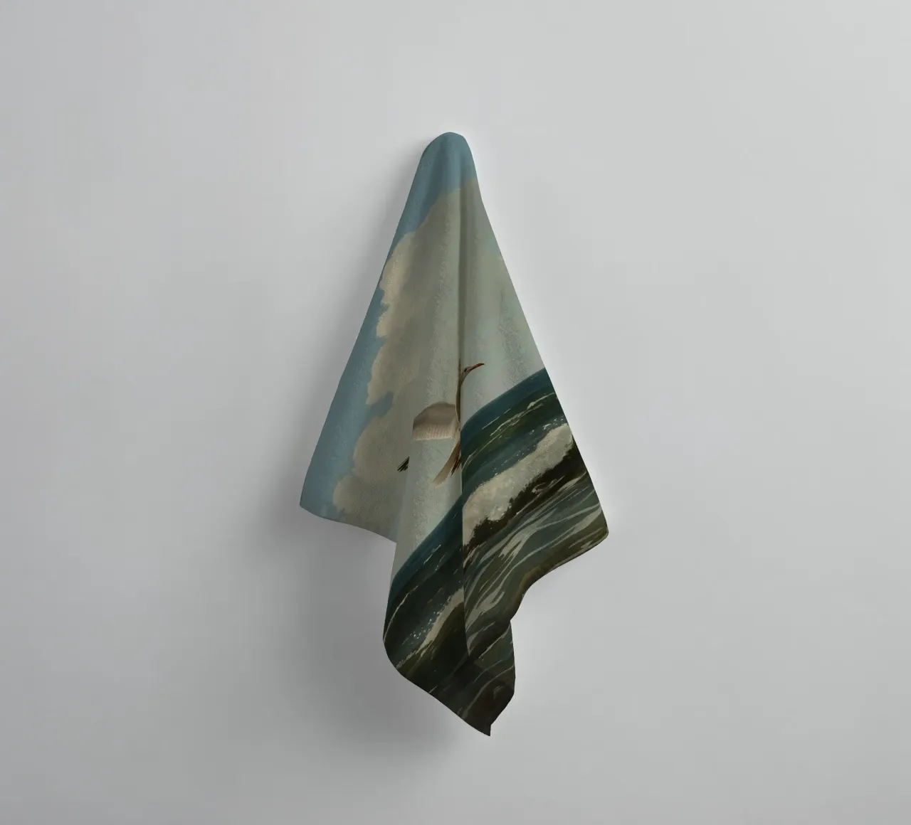 Seagull gliding over ocean waves under a partly cloudy sky towel by DesignDoodle