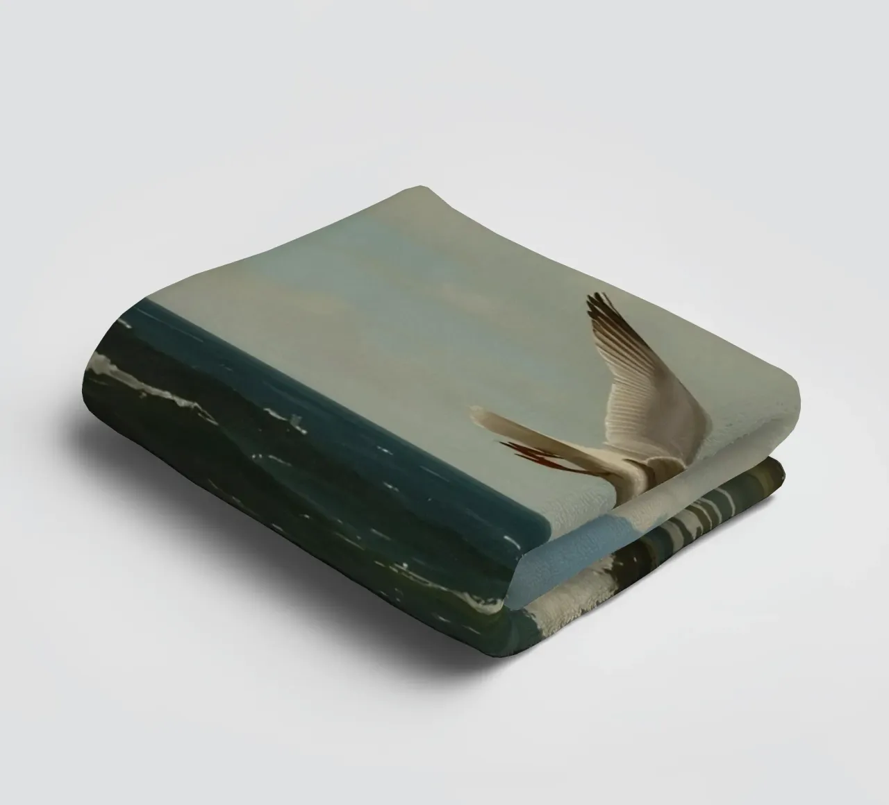 Seagull gliding over ocean waves under a partly cloudy sky towel by DesignDoodle