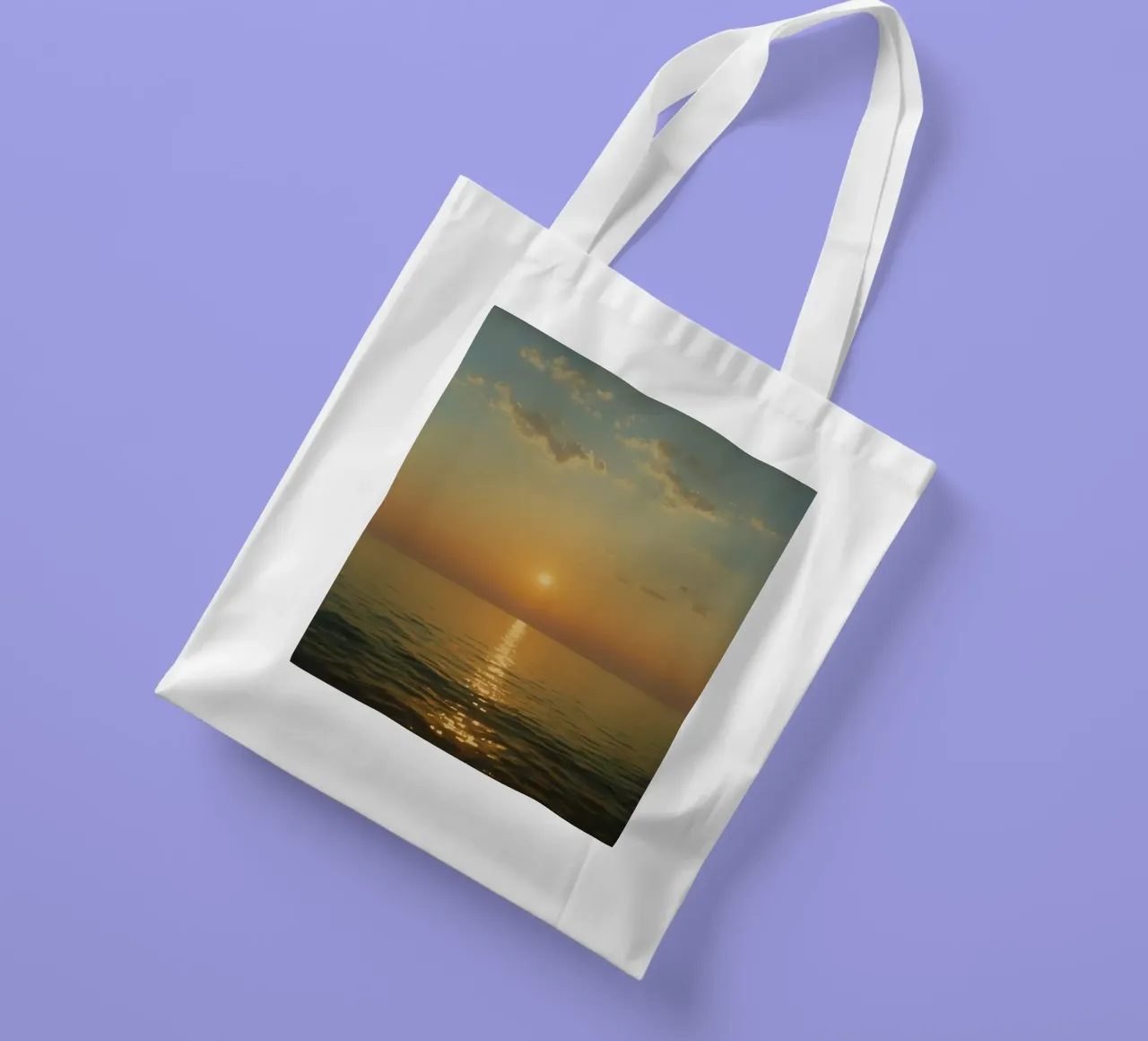 Sunset over the calm ocean waters with reflective golden hue tote bag by DesignDoodle