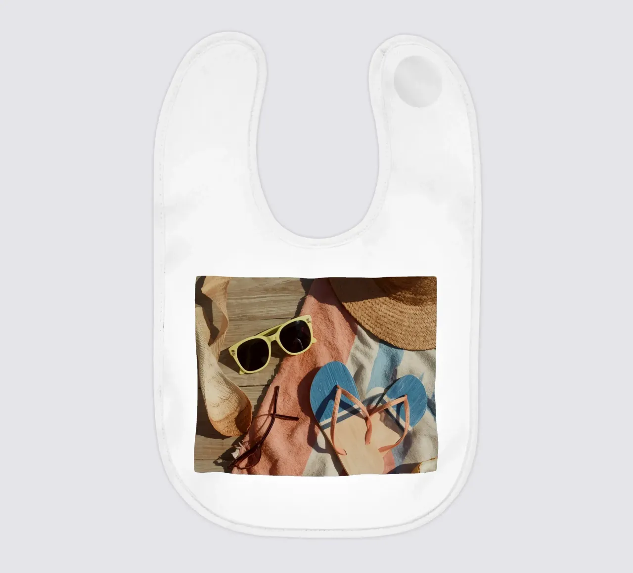 Accessori da spiaggia su asciugamano a righe e superficie in legno bavaglino da DesignDoodle
