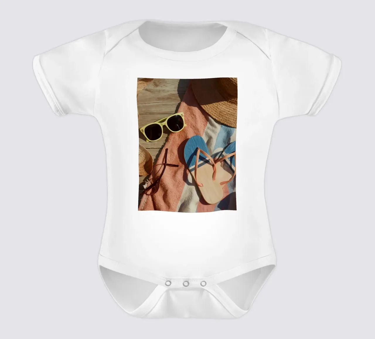 Accessori da spiaggia su asciugamano a righe e superficie in legno body neonato maniche corte da DesignDoodle