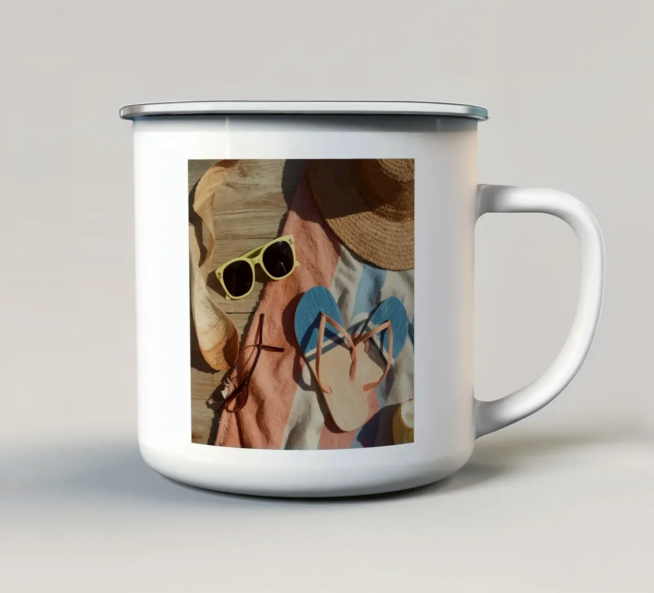 Accessori da spiaggia su asciugamano a righe e superficie in legno tazza in smalto da DesignDoodle