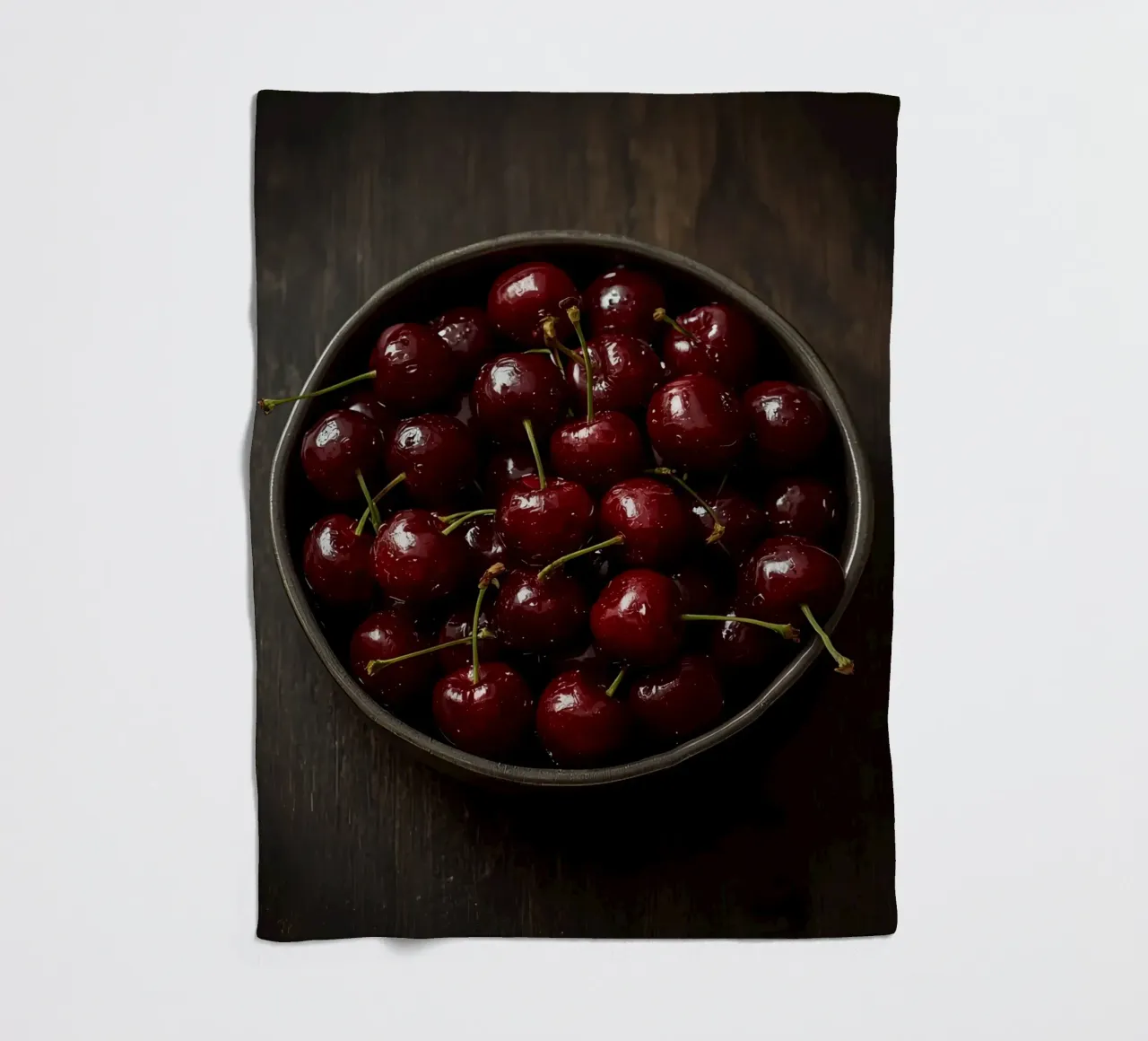 Schale mit dunkelroten Kirschen auf Holzoberfläche Fleecedecke von DesignDoodle