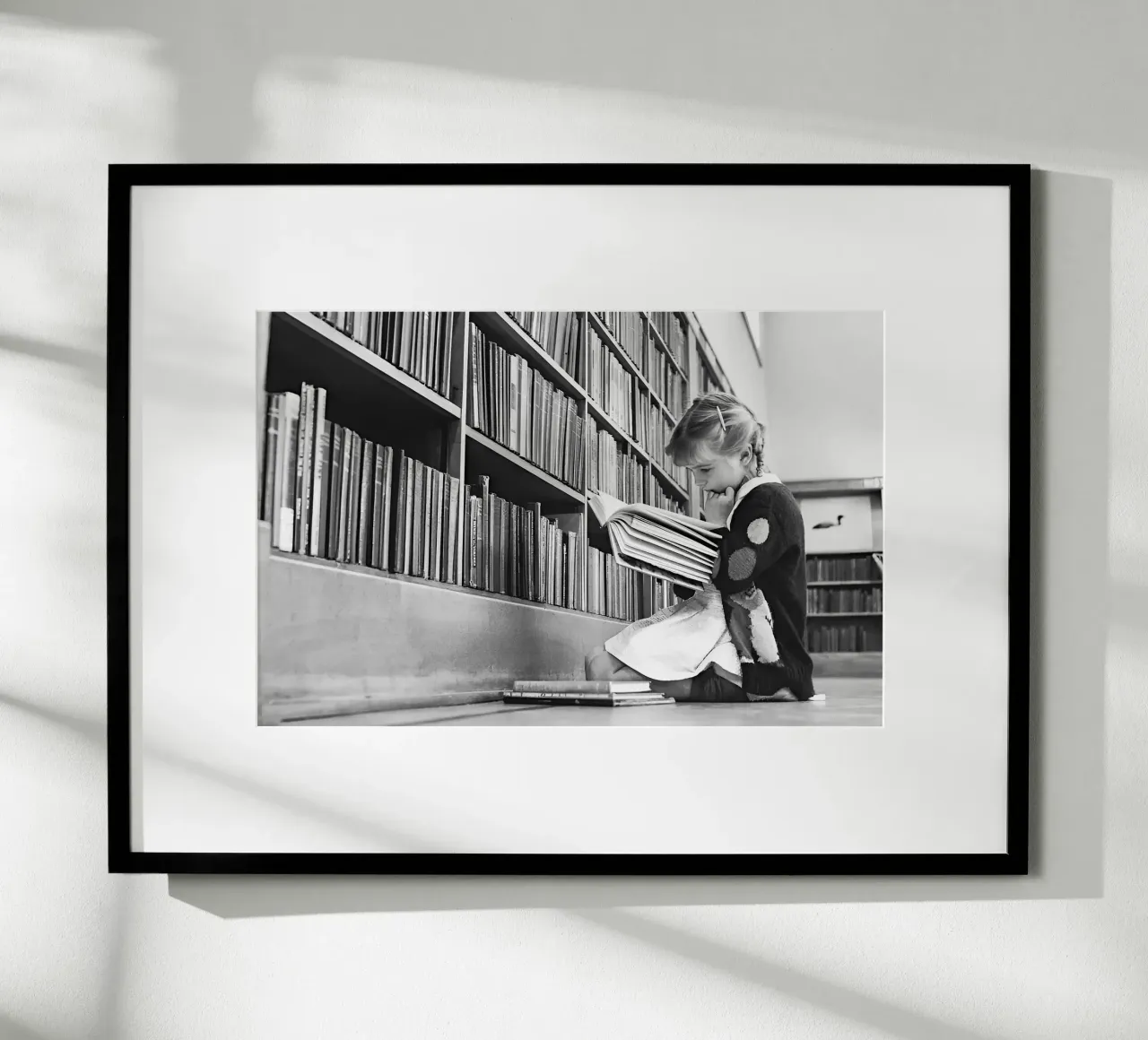Bambina che legge un libro, foto d'epoca in bianco e nero poster con telaio in legno da Vibrant Vintage Prints