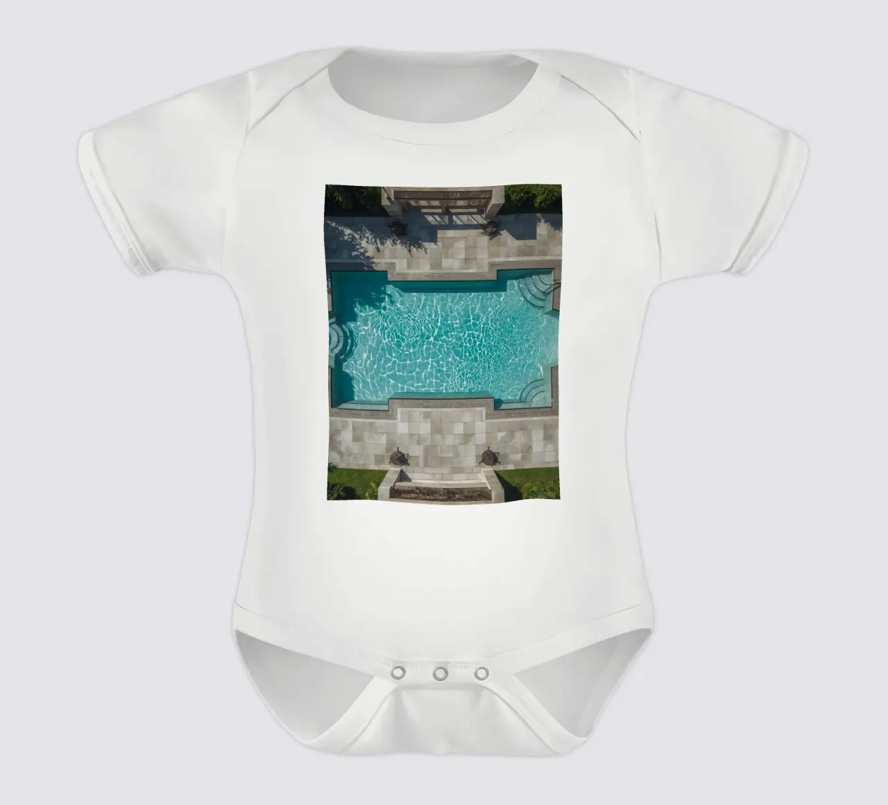 Vue aérienne d'une piscine rectangulaire avec un patio en pierre body bébé de DesignDoodle