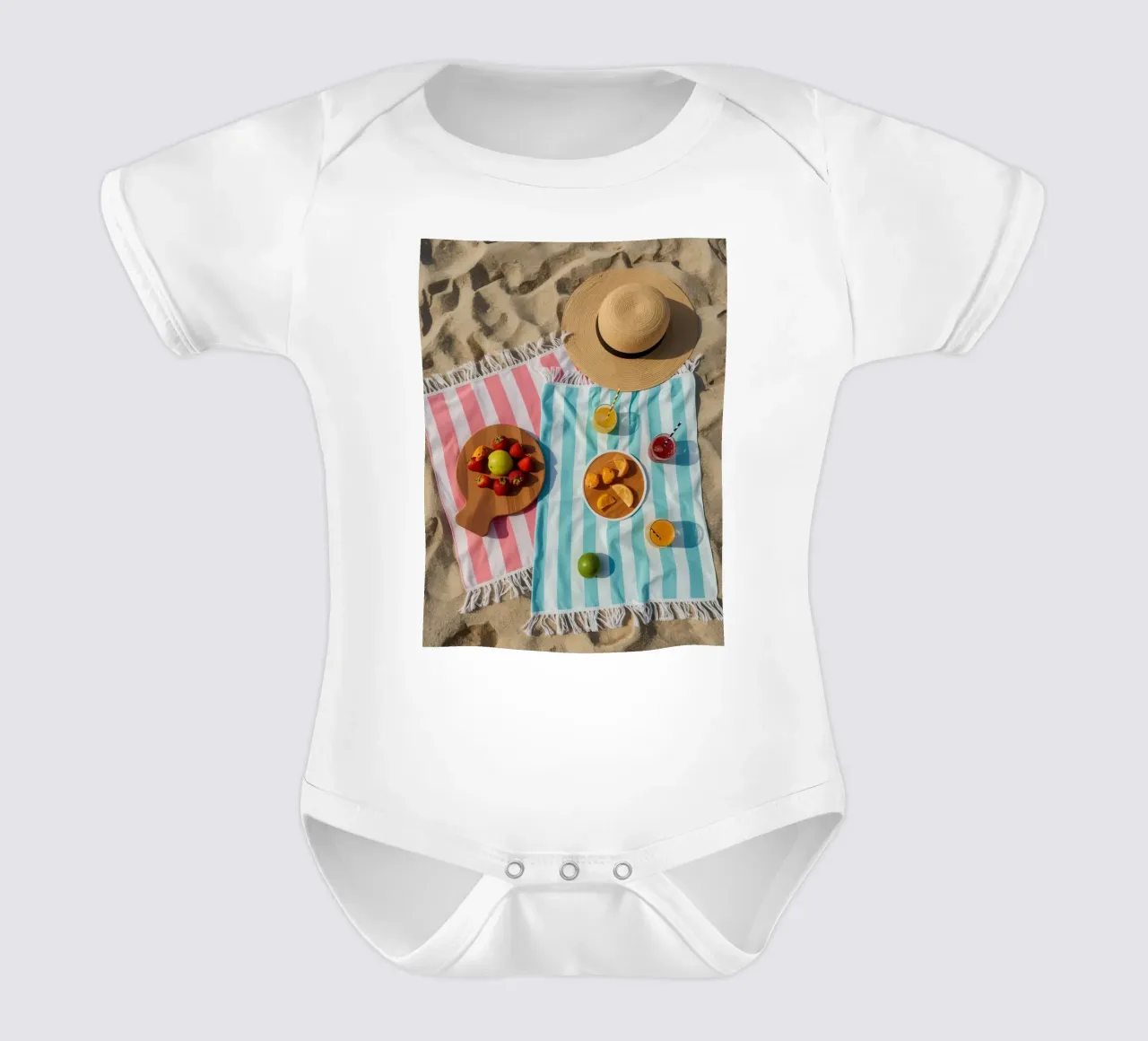 Scena di spiaggia con asciugamani, bevande alla frutta e cappello di paglia body neonato maniche corte da DesignDoodle