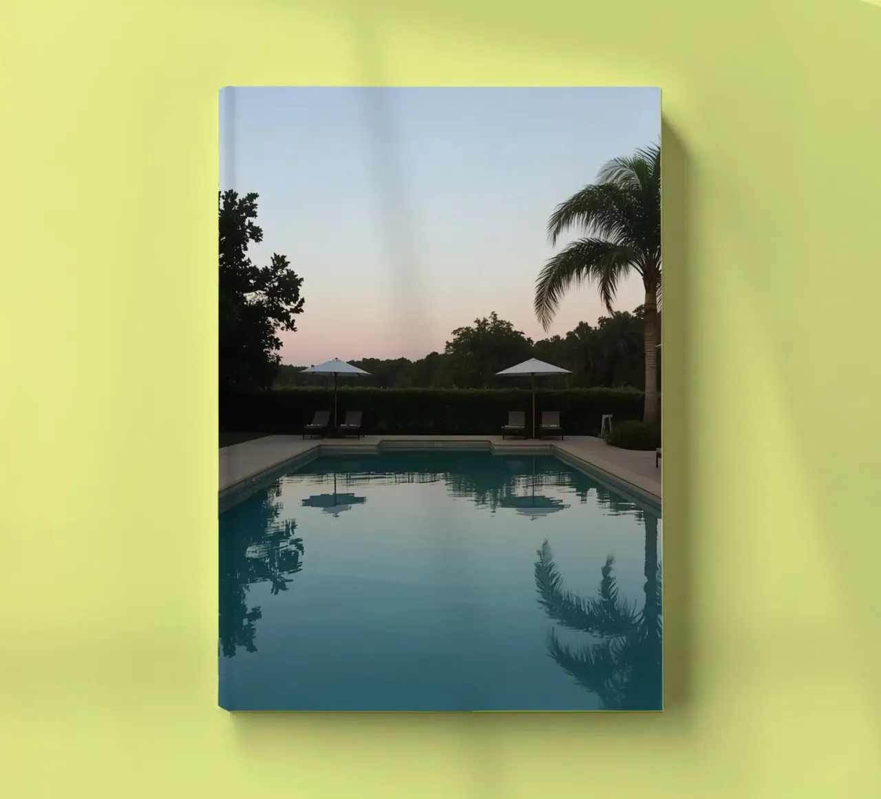 Swimming Pool Reflecting Palm Trees and Umbrellas at Dusk notebook by DesignDoodle