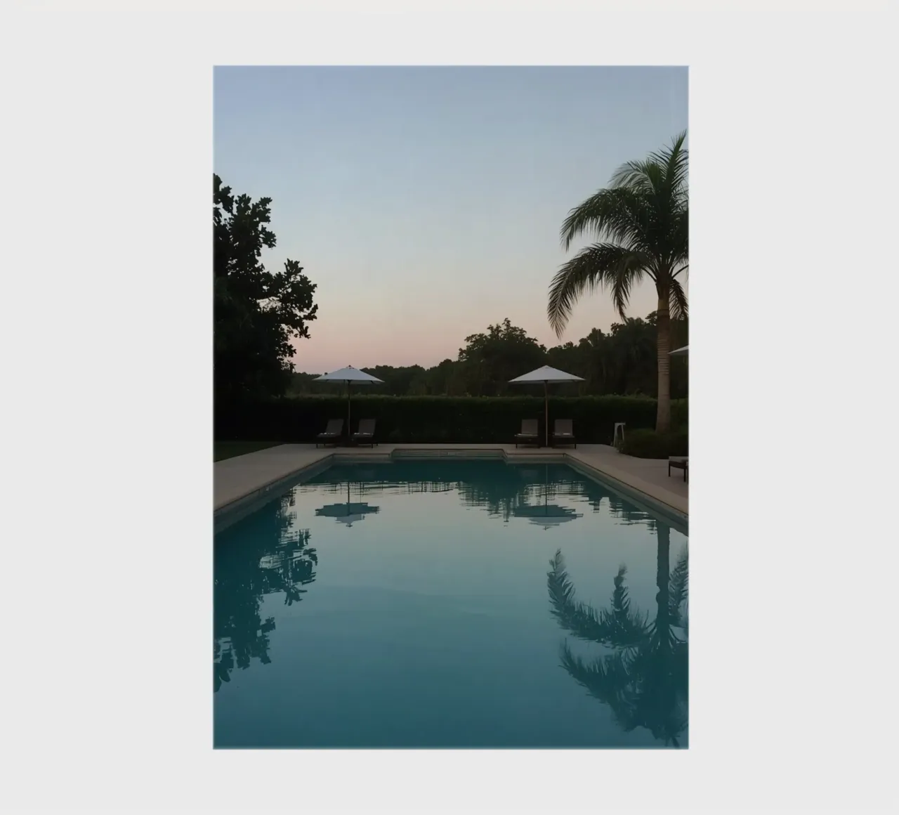 Swimming Pool Reflecting Palm Trees and Umbrellas at Dusk notebook by DesignDoodle