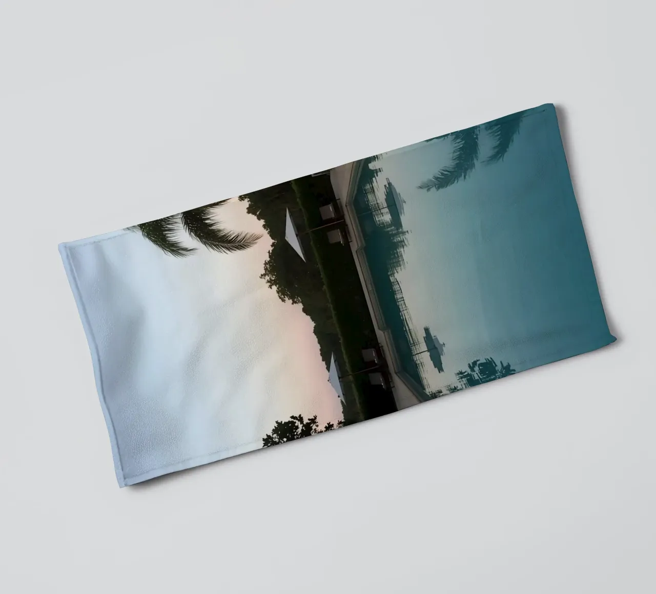 Swimming Pool Reflecting Palm Trees and Umbrellas at Dusk towel by DesignDoodle