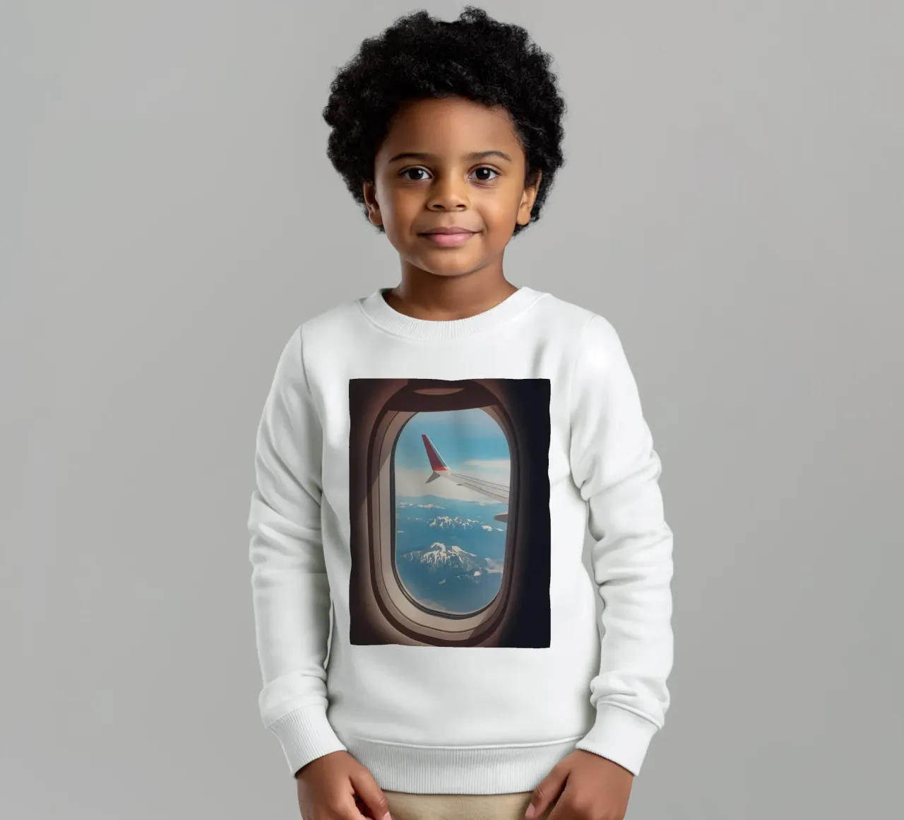 Vue d'un hublot d'avion sur une aile et des montagnes sweat enfant de DesignDoodle