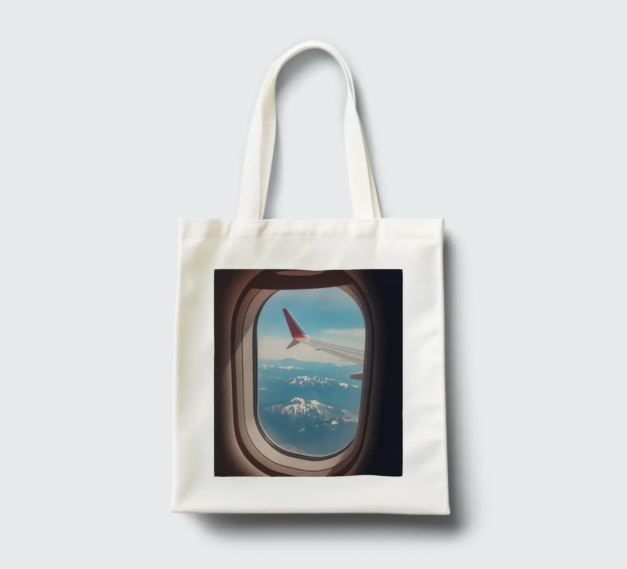 Vue d'un hublot d'avion sur une aile et des montagnes tote bag de DesignDoodle